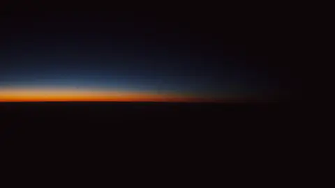 Le dégradé de l'aube au ras d'un horizon marin entièrement dégagé, du bleu nuit à l'orange, sans le moindre relief.