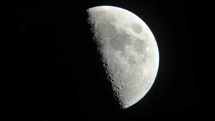 Une Lune gibbeuse photographiée au télescope : le long de la ligne d'ombre, les cratères sortent en relief sous la lumière rasante, tandis que la partie pleinement éclairée paraît plate.