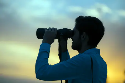 Des observateurs scrutent le ciel aux jumelles à la tombée de la nuit : l'instrument qu'il faut, et qu'il suffit, pour trouver Neptune.